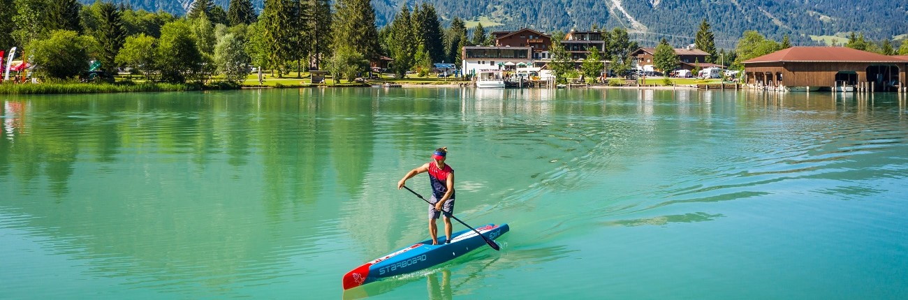 starboard man on lake race SUP stand up surf shop 1300x430